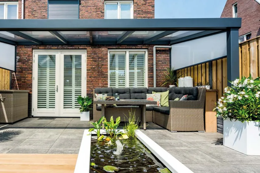 Deponti Giallo: Terrassenüberdachung mit gerader Rinne an einem Klinkerhaus